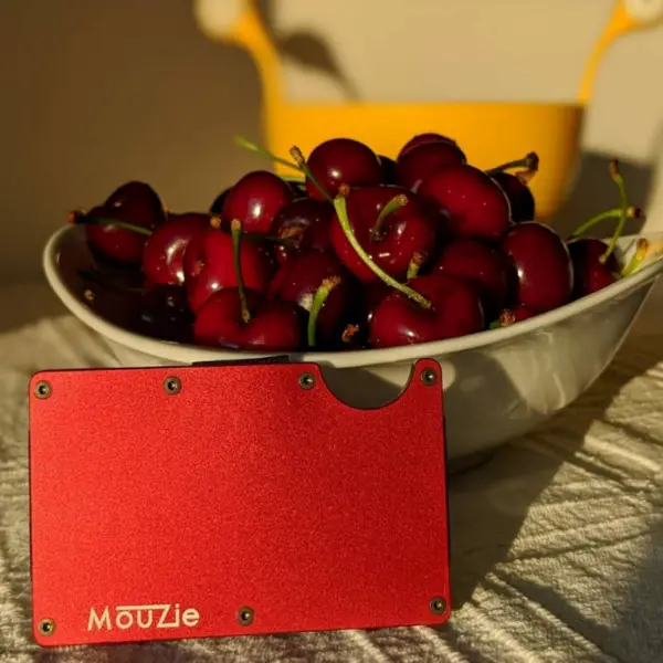 Mouzie wallet red color next to cherries