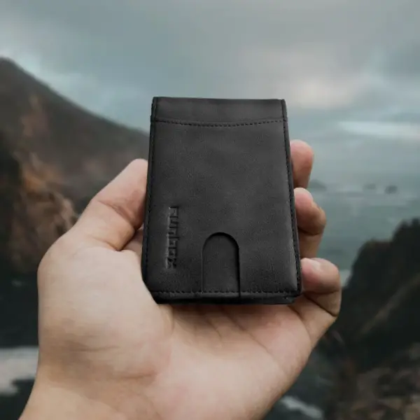 Runbox Minimalist Slim held in hand, with mountains in backround