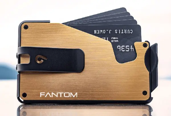 front view of a gold Fantom Aluminum wallet with several black cards in it