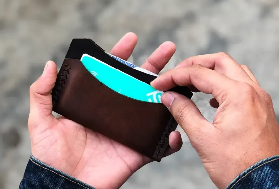person holding a minimalist cardholder wallet