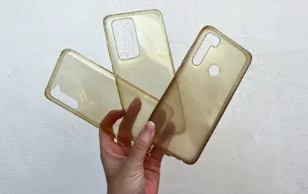 hand holding 3 old phone cases